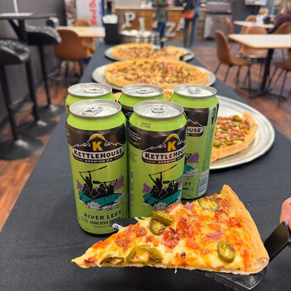 A slice of Tossers Pizza with jalapeños and bacon, alongside KettleHouse beer cans and whole pizzas.